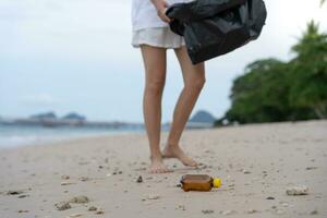 salvar océano. voluntario recoger arriba basura basura a el playa y el plastico botellas son difícil descomponer evitar daño acuático vida. tierra, ambiente, verdeado planeta, reducir global calentamiento, salvar mundo foto