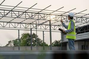 inspector or engineer is inspecting construction and quality assurance new house using a checklist. Engineers or architects or contactor work to build the house before handing it over to the homeowner photo