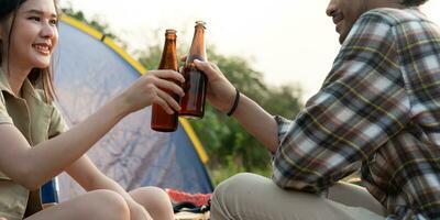 asiático marido y esposa bebida mientras cámping en el selva. aventuras, nuevo parejas, amigos, vacaciones, relajación, naturaleza, relajación, clima bien, viajar, Luna de miel, senderismo, naturaleza viajar, viajero foto