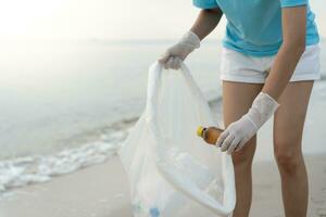 Save water. Volunteer pick up trash garbage at the beach and plastic bottles are difficult decompose prevent harm aquatic life. Earth, Environment, Greening planet, reduce global warming, Save world photo