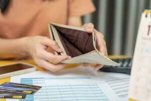 Stressed and headache woman with large bills or invoices no money to pay to expenses and credit card debt. shortage, Financial problem, bankruptcy, mortgage, loan, bankrupt, poor, empty wallet photo