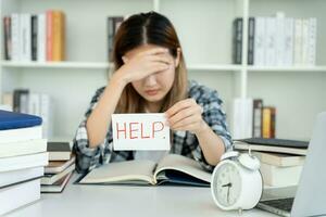 Asian student woman have anxiety because of exams, female prepare for test and learning lessons in the library. stress, despair, haste, misunderstanding reading, discouraged, expectation, knowledge photo