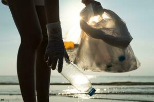 Save water. Volunteer pick up trash garbage at the beach and plastic bottles are difficult decompose prevent harm aquatic life. Earth, Environment, Greening planet, reduce global warming, Save world photo