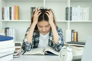 las estudiantes asiáticas tienen ansiedad debido a los exámenes, las mujeres se preparan para las pruebas y aprenden lecciones en la biblioteca. estrés, desesperación, prisa, malentendido lectura, desaliento, expectativa, conocimiento foto