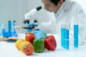 el científico comprueba los residuos de alimentos químicos en el laboratorio. expertos en control inspeccionan la calidad de frutas, verduras. laboratorio, peligros, rohs, encontrar sustancias prohibidas, contaminar, microscopio, microbiólogo foto