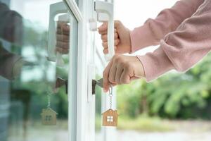 Landlord key for unlocking house is plugged into the door. Second hand house for rent and sale. Owner use hand unlock door mortgage for new home, buy, sell, renovate, investment, owner, estate photo