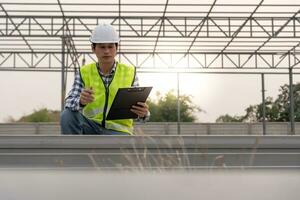 inspector or engineer is inspecting construction and quality assurance new factory using a checklist. Engineers or architects or contactor work to build the factory before handing it over to the home photo