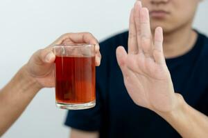 man refuses say no and avoid to drink an alcohol whiskey , stopping hand sign male, alcoholism treatment, alcohol addiction, quit booze, Stop Drinking Alcohol. Refuse Glass liquor, unhealthy, reject photo