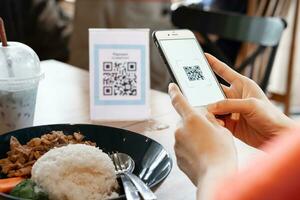 Woman use smartphone to scan QR code to pay in cafe restaurant with a digital payment without cash. Choose menu and order accumulate discount. E wallet, technology, pay online, credit card, bank app. photo