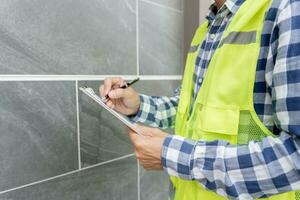 inspector or engineer is inspecting construction and quality assurance new house using a checklist. Engineers or architects or contactor work to build the house before handing it over to the homeowner photo
