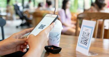 mujer utilizar teléfono inteligente a escanear qr código para orden menú en café restaurante con un digital entrega. escoger menú y orden acumular descuento. mi billetera, tecnología, pagar en línea, crédito tarjeta, banco aplicación foto