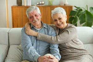 Senior adult mature couple hugging at home. Mid age old husband and wife embracing with tenderness love enjoying sweet bonding wellbeing. Grandmother grandfather together. Family moment love and care. photo