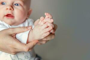 Young mother and newborn child clap their hands photo