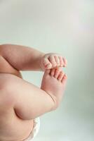 minúsculo recién nacido infantil masculino o hembra bebé pies y dedos de los pies en blanco antecedentes. foto