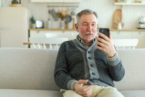 Happy middle aged senior man talk on video call with friends family. Laughing mature old senior grandfather having fun speaking with grown up children online. Older generation modern tech usage. photo