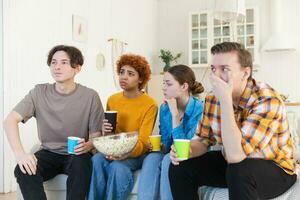 Group of friends watching sport match soccer football game on tv at home. Football fans disappointed missing goal loosing game. Friendship sports entertainment. Buddies watching championship together. photo