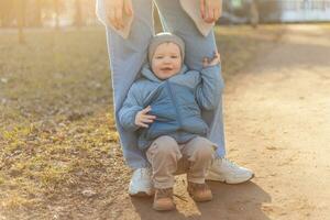 contento familia exterior. madre niño en caminar en parque. mamá jugando con bebé hijo exterior. mujer pequeño bebé chico descansando caminando en naturaleza. pequeño niñito niño y niñera niñera teniendo divertido juntos. foto