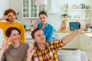 Cheers Funky mood. Happy group of friends make selfie. Man taking photo of friends at party. Group of multiracial young people taking photo on phone. Young people enjoy their company smile have fun.