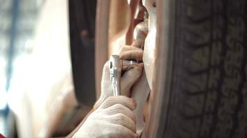 Asian man car mechanic replacing a car tire in garage workshop. . Auto service, Car-care center removes the wheel, Repair and maintenance of the car in service. photo