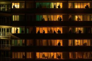 Apartments with silhouettes of people in the windows at night. ,Generative AI photo