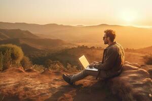 Digital nomad sitting on top of a hill working with his laptop over the city at sunset ,Generative AI. photo