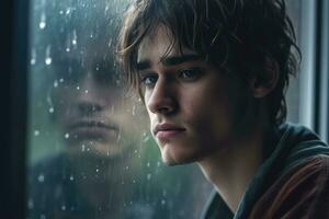 A young man sad of sit on the edge the window with raindrops on the glass window on a rainy day ,Generative AI. photo
