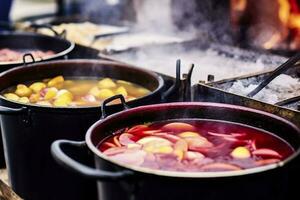 Beverages fruits and berries hot mulled wine in pots with steam in street food market. Generative AI photo