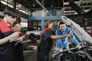 masculino profesional automotor supervisor aconseja y inspecciona negro hembra mecánico trabajador acerca de líquido motor petróleo a coche cochera, Servicio mantenimiento, y fijación especialista ocupaciones auto industria. foto