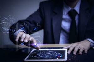 Businessman writes signing contract, designs, draws, or sketches projects through a tablet on the office desk. Hand concept stamp of approval on a public notarization certificate document electronic. photo