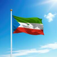 Waving flag of Equatorial Guinea on flagpole with sky background. photo