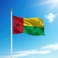 Waving flag of Guinea-Bissau on flagpole with sky background. photo