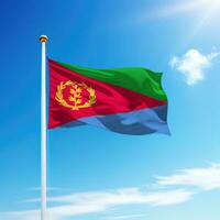 Waving flag of Eritrea on flagpole with sky background. photo