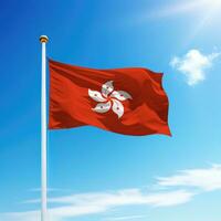 Waving flag of Hong Kong on flagpole with sky background. photo