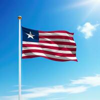 Waving flag of Liberia on flagpole with sky background. photo