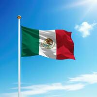 Waving flag of Mexico on flagpole with sky background. photo