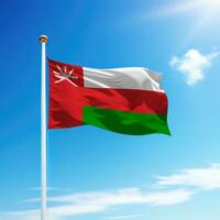 Waving flag of Oman on flagpole with sky background. photo