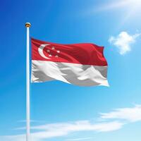 Waving flag of Singapore on flagpole with sky background. photo