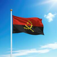 Waving flag of Angola on flagpole with sky background. photo