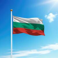 ondulación bandera de Bulgaria en asta de bandera con cielo antecedentes. foto