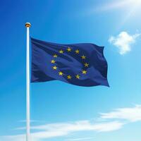 Waving flag of European Union on flagpole with sky background. photo