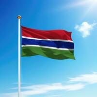 Waving flag of Gambia on flagpole with sky background. photo