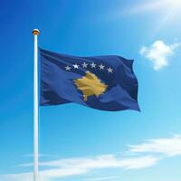 ondulación bandera de Kosovo en asta de bandera con cielo antecedentes. foto