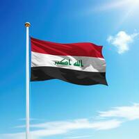 Waving flag of Iraq on flagpole with sky background. photo