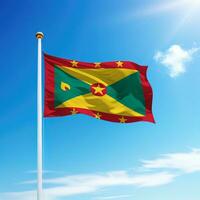 Waving flag of Grenada on flagpole with sky background. photo