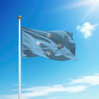 ondulación bandera de micronesia en asta de bandera con cielo antecedentes. foto