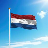 ondulación bandera de Países Bajos en asta de bandera con cielo antecedentes. foto