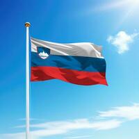 Waving flag of Slovenia on flagpole with sky background. photo