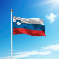 Waving flag of Slovenia on flagpole with sky background. photo