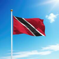 Waving flag of Trinidad and Tobago on flagpole with sky background. photo