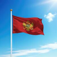 Waving flag of Montenegro on flagpole with sky background. photo
